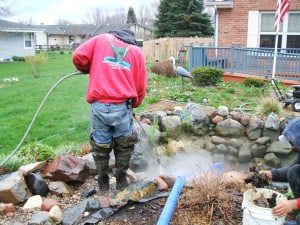 One of the guys cleaning a client's pond