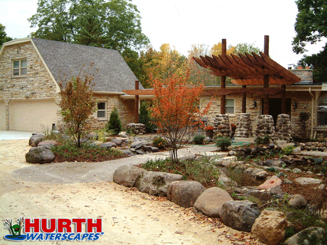 front yard landscape with boulders walks and stream pond
